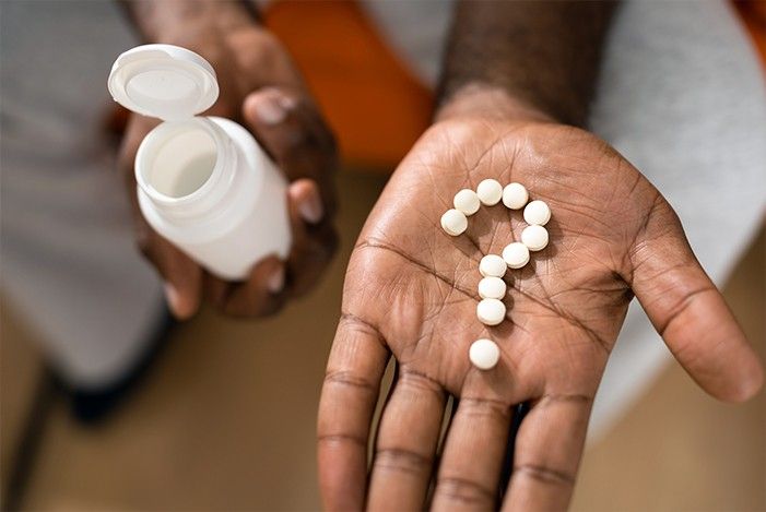 Auf einer Handfleche ist aus Tabletten ein Fragezeichen geformt.jpg