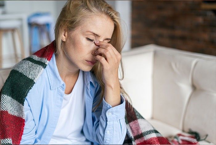 Frau mit Decke über den Schulern wirkt erschöpft.jpg