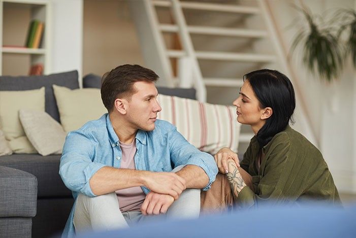 Mann und Frau sitzend vor dem Sofa sie blicken sie an.jpg
