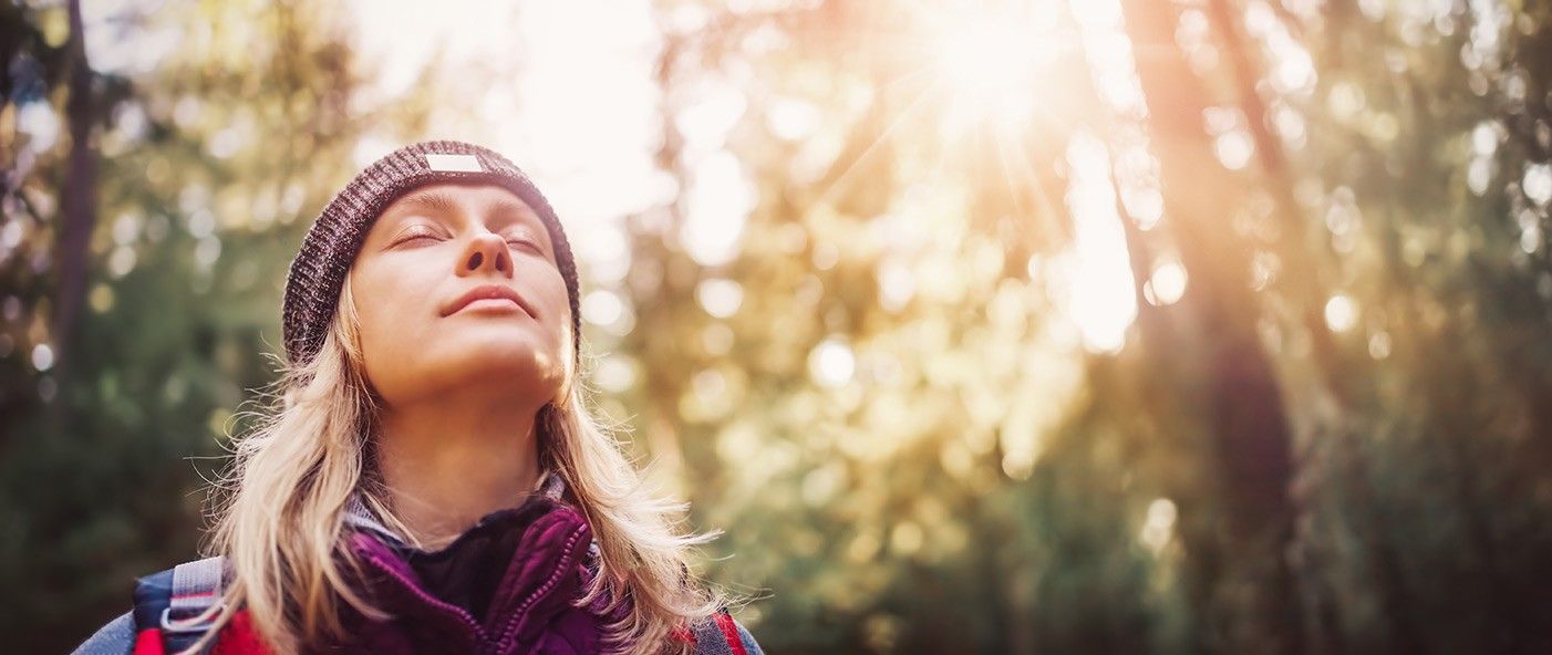 frau-mit-kappe-und-geschlossenen-augen-im-wald.jpg