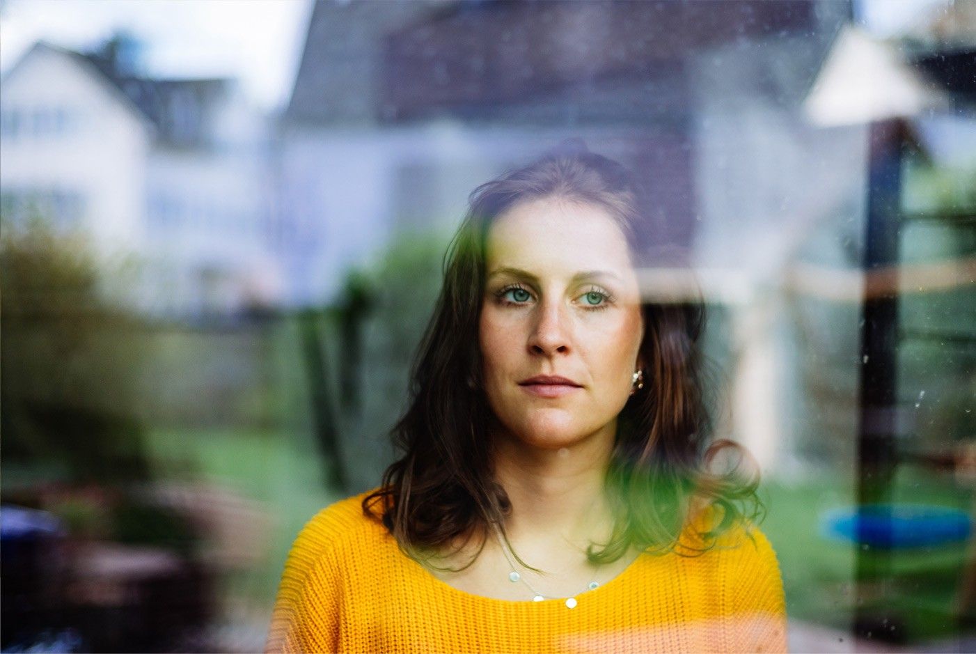 frau-schaut-mit-verlorenem-blick-durch-ein-fenster.jpg